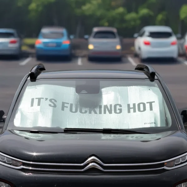 מגן שמש קדמי לרכב מתקפל מבית Fisura עם כיתוב It’s Fucking Hot – חוסם UV ושומר על הרכב קריר.